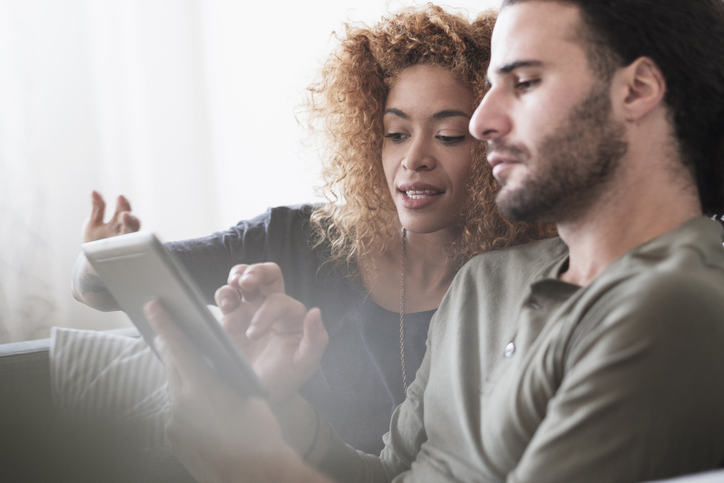 Young couple shopping for flooring using tablet