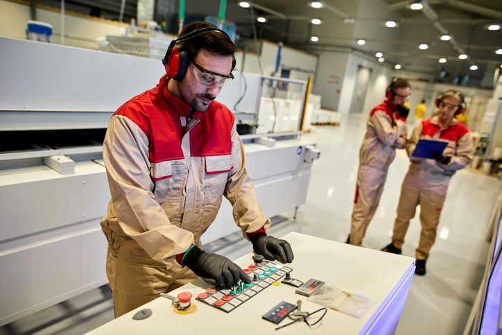 Two colleagues closely examining a desktop monitor together in a creative office environment.