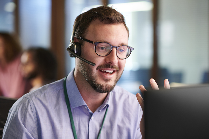 An IT support professional wearing a headset, engaged in a virtual call, offering customer service or technical assistance.