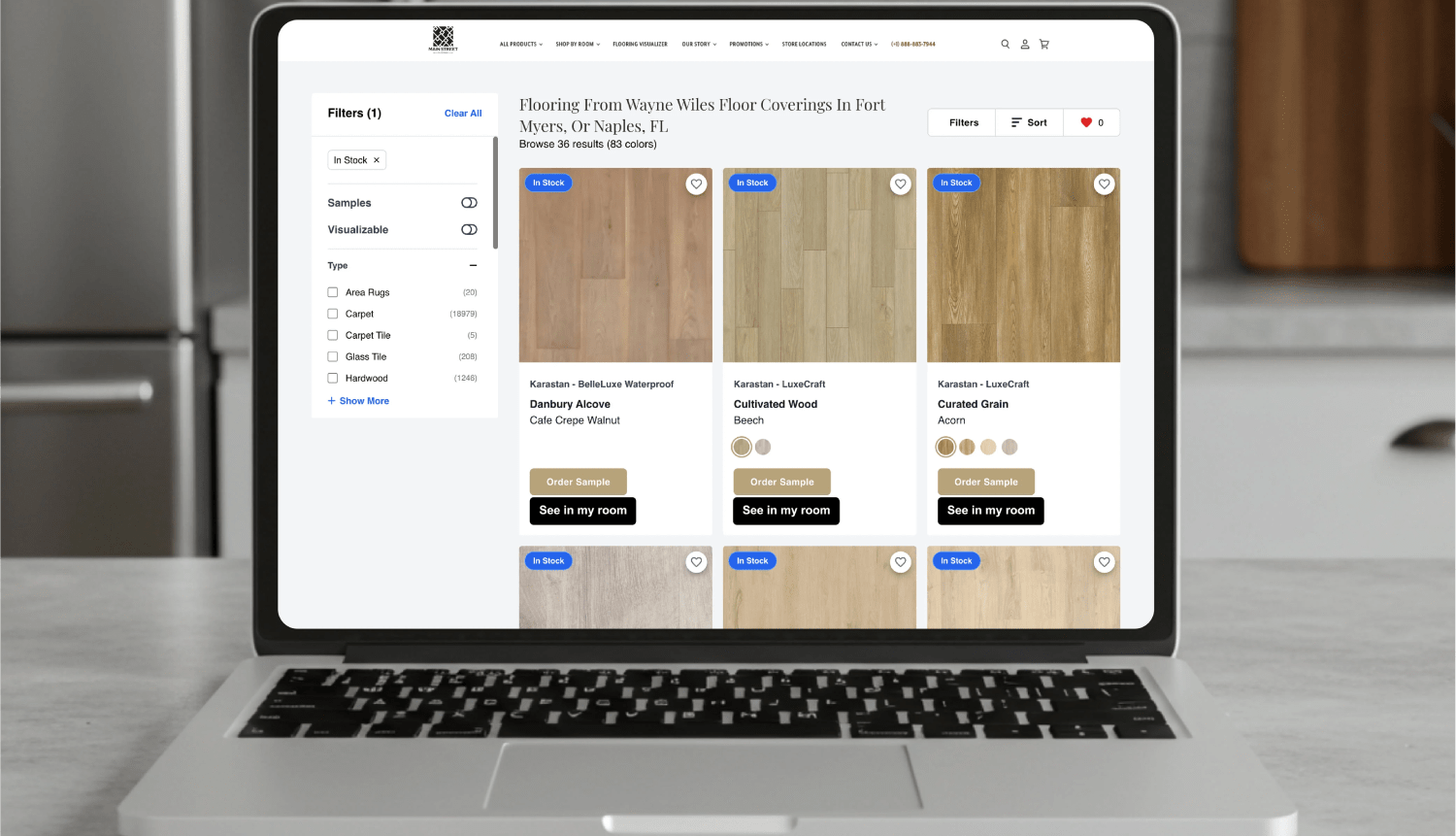Laptop screen displaying an online flooring catalog with product images, filter options, and buttons to order samples or preview floors in a virtual room.