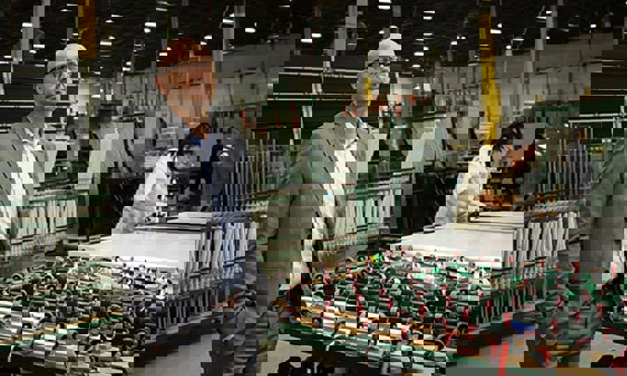 A well-dressed man stands before a machine